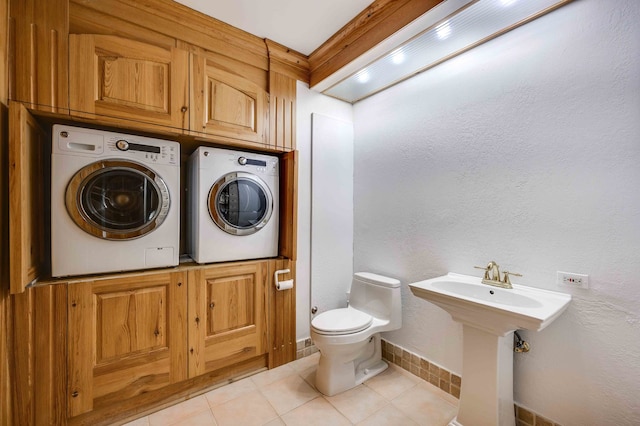 clothes washing area with independent washer and dryer and light tile patterned floors