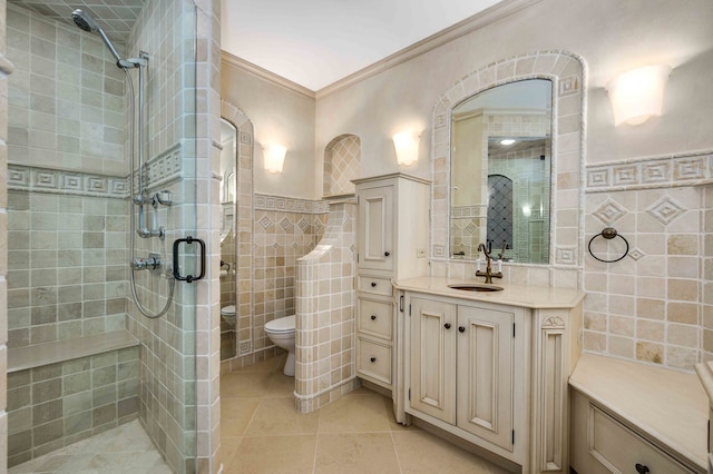 bathroom with tile patterned floors, toilet, crown molding, tile walls, and vanity