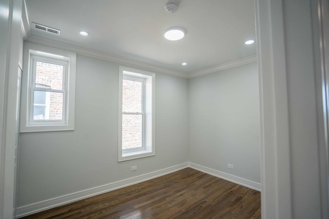 empty room with ornamental molding and dark wood-type flooring