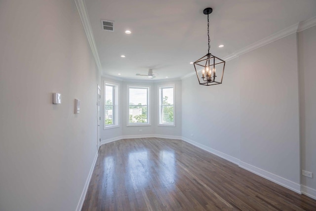 unfurnished room featuring dark hardwood / wood-style flooring, an inviting chandelier, and crown molding