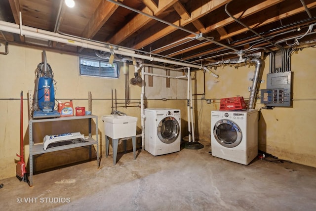 laundry area with independent washer and dryer, electric panel, and sink