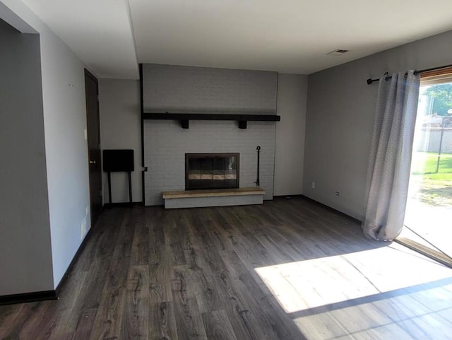 unfurnished living room featuring a fireplace and dark wood-type flooring