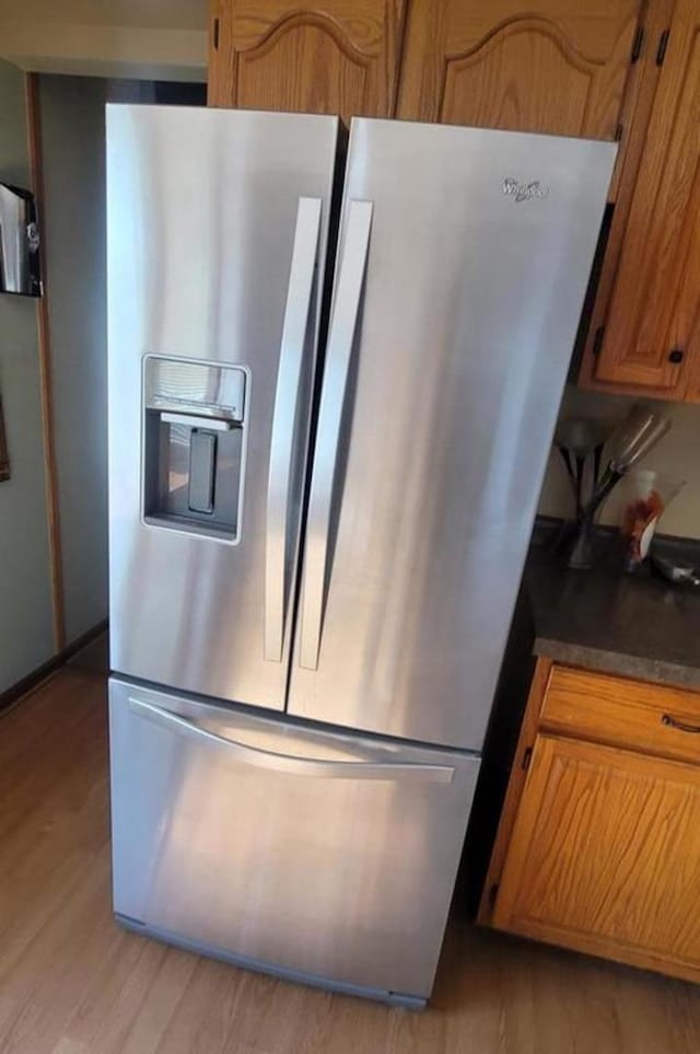 kitchen with stainless steel fridge with ice dispenser and light hardwood / wood-style flooring