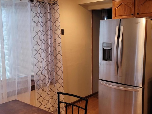 kitchen with stainless steel refrigerator with ice dispenser and light wood-type flooring