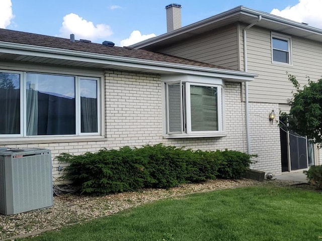 view of property exterior featuring central AC unit and a yard