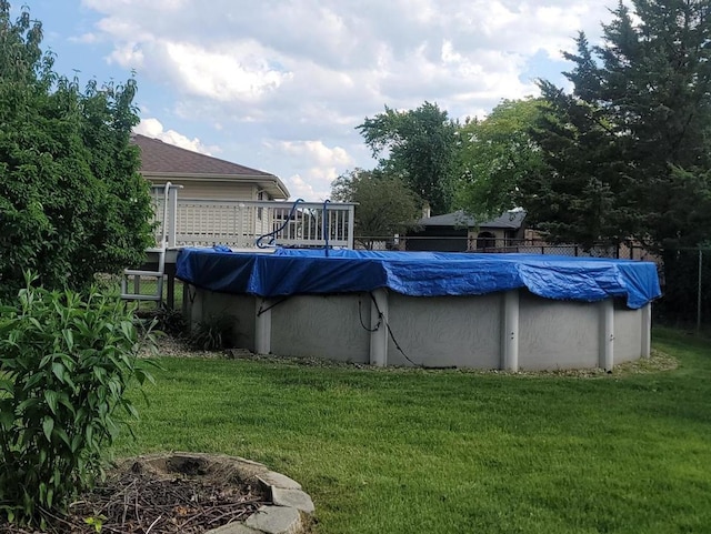 view of pool featuring a lawn and a deck