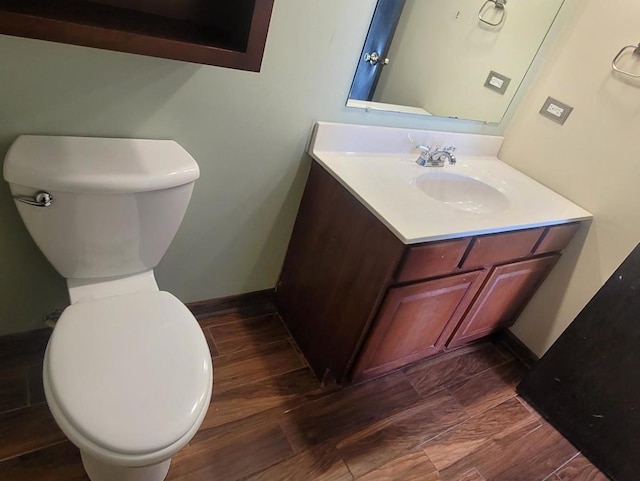 bathroom with toilet, vanity, and hardwood / wood-style flooring