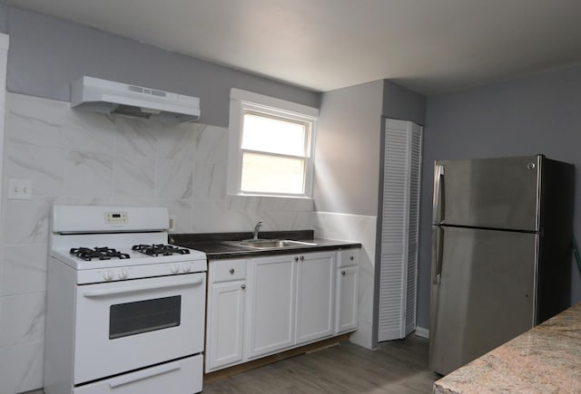 kitchen featuring stainless steel refrigerator, gas range gas stove, sink, dark hardwood / wood-style flooring, and ventilation hood