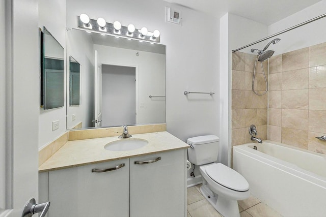 full bathroom with tile patterned flooring, toilet, vanity, and tiled shower / bath