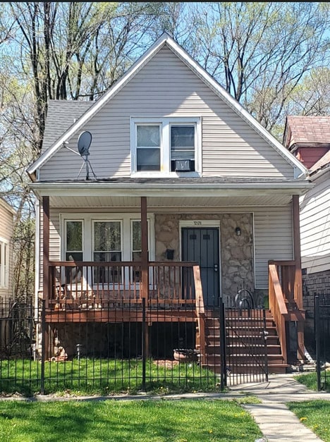 bungalow with covered porch and a front lawn