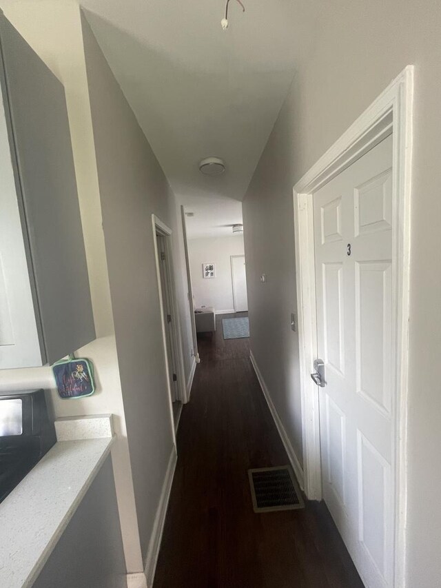 hallway with dark hardwood / wood-style flooring