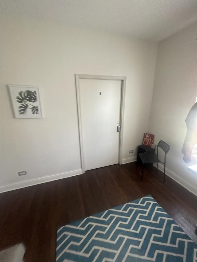 unfurnished room featuring baseboards and wood finished floors