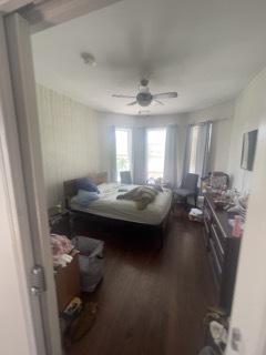 bedroom with dark hardwood / wood-style floors and ceiling fan