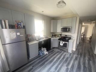 kitchen with gray cabinets, light countertops, appliances with stainless steel finishes, and dark wood-style flooring