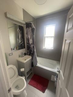 bathroom with tile patterned flooring, toilet, and shower / tub combo