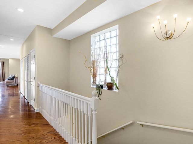 hall with a chandelier and dark wood-type flooring