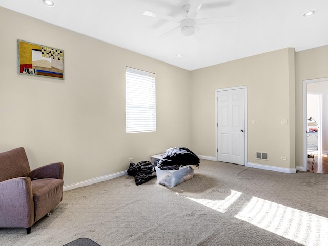 living area featuring ceiling fan and light carpet