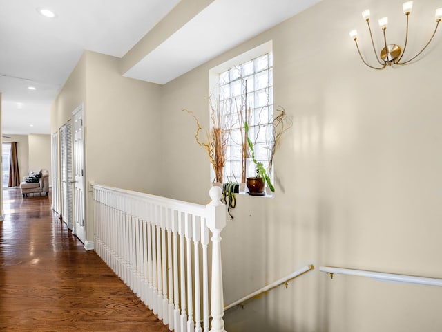 hallway with dark hardwood / wood-style flooring and a chandelier