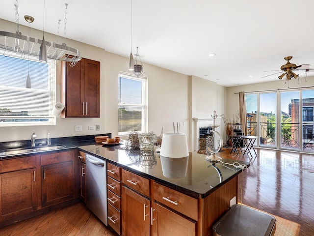 kitchen featuring hardwood / wood-style floors, dishwasher, sink, hanging light fixtures, and ceiling fan