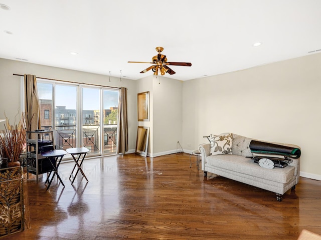 living area featuring ceiling fan and dark hardwood / wood-style floors