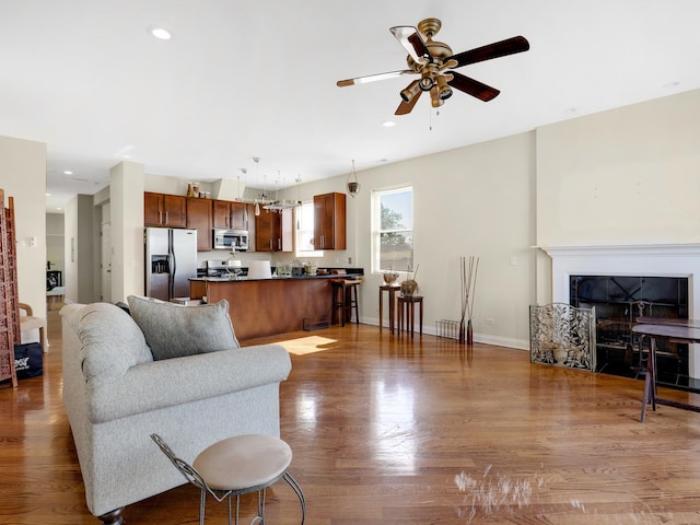 living room featuring ceiling fan and dark wood-type flooring