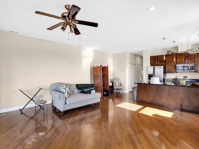 living room with ceiling fan and dark hardwood / wood-style flooring