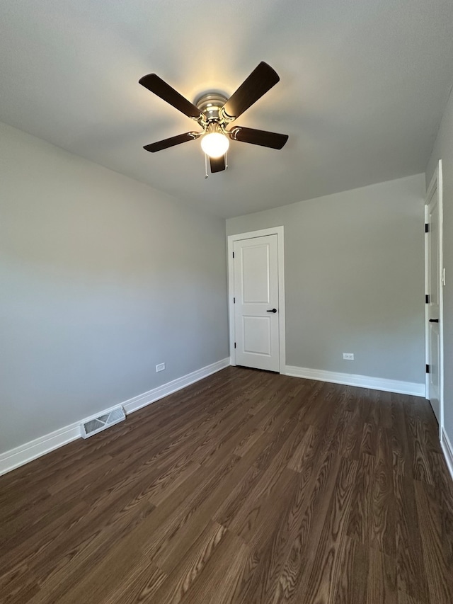 spare room with dark hardwood / wood-style floors and ceiling fan