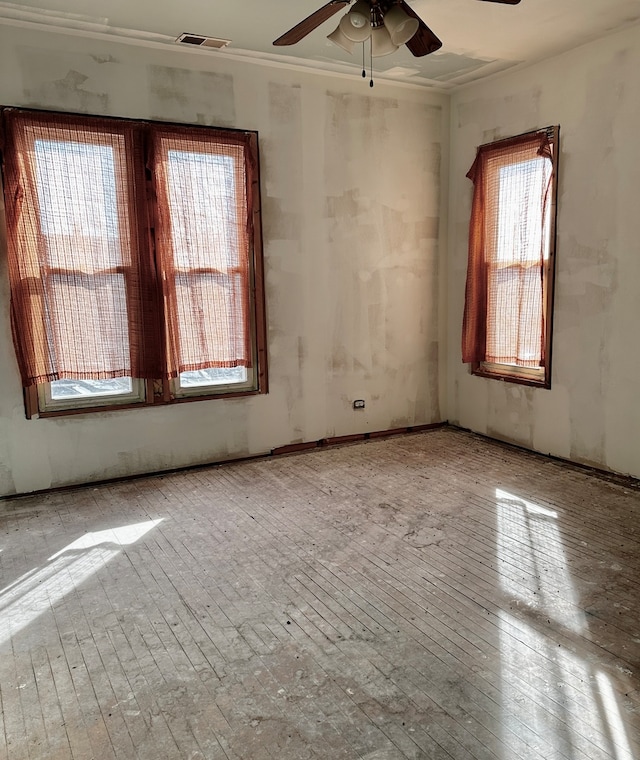 unfurnished room featuring a healthy amount of sunlight and ceiling fan