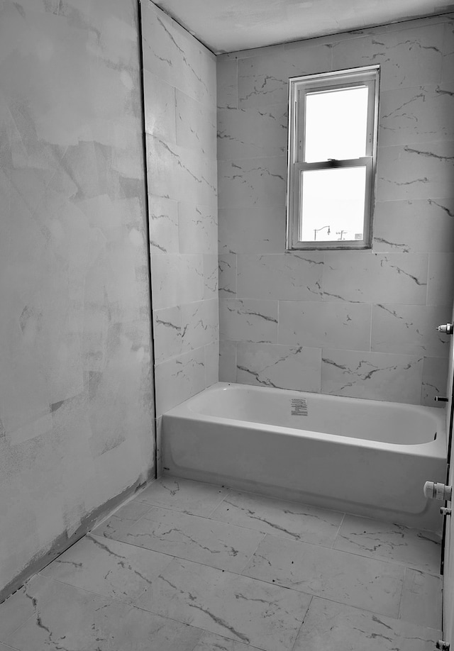 bathroom featuring tiled shower / bath and tile flooring