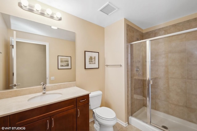 bathroom with tile patterned floors, vanity, toilet, and a shower with door