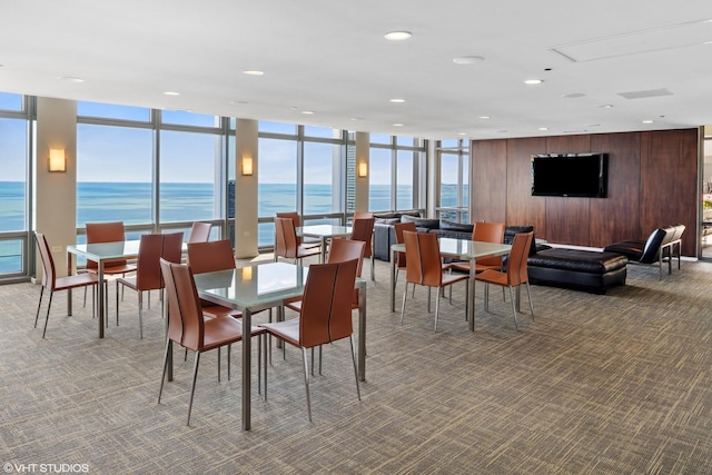 carpeted dining area with expansive windows and wooden walls