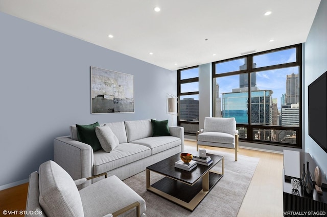 living room featuring a wall of windows and light wood-type flooring