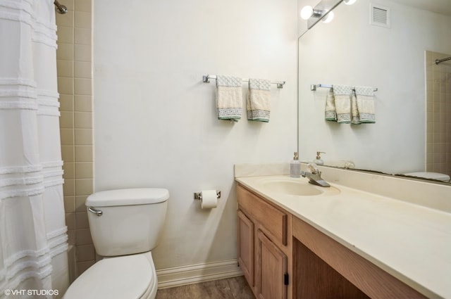 bathroom featuring wood-type flooring, vanity with extensive cabinet space, and toilet