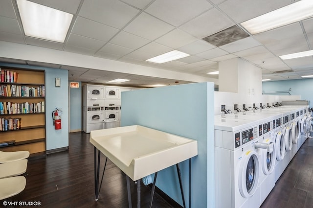 clothes washing area featuring dark wood-type flooring, washer and clothes dryer, and stacked washer / drying machine