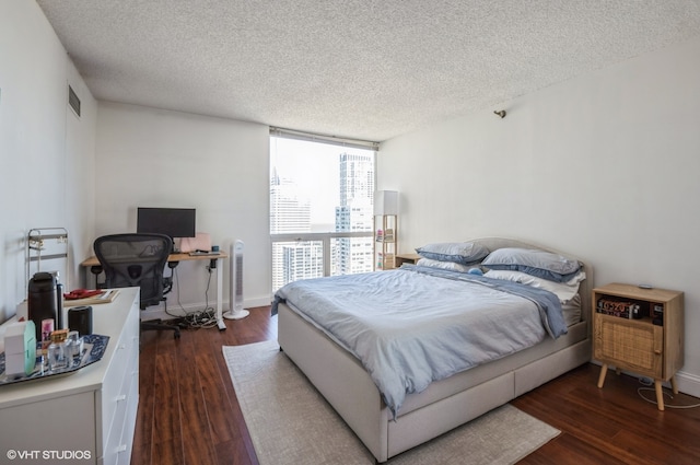 bedroom featuring a textured ceiling and dark wood-type flooring