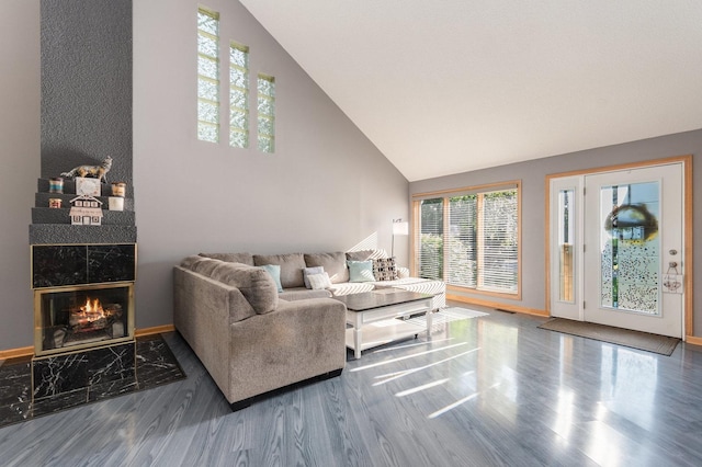 living room featuring hardwood / wood-style floors, a high end fireplace, and high vaulted ceiling