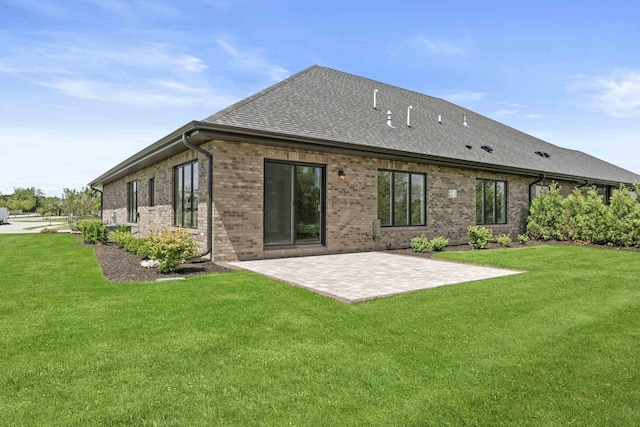 rear view of house with a patio, a shingled roof, a yard, and brick siding
