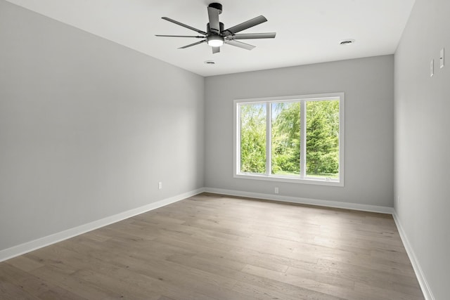 empty room with baseboards, light wood-style floors, ceiling fan, and visible vents