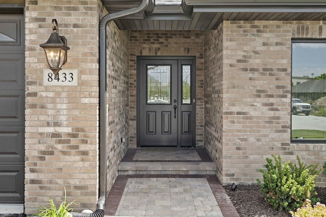 entrance to property featuring brick siding