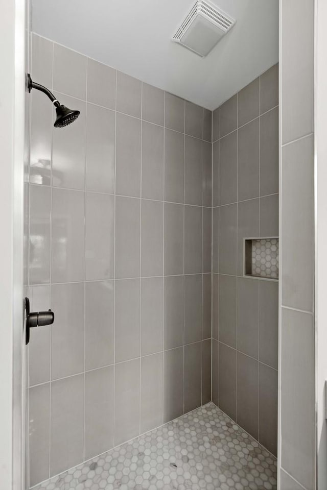 bathroom with visible vents and tiled shower