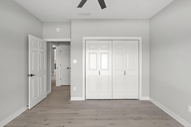 unfurnished bedroom with visible vents, a closet, baseboards, ceiling fan, and light wood-type flooring