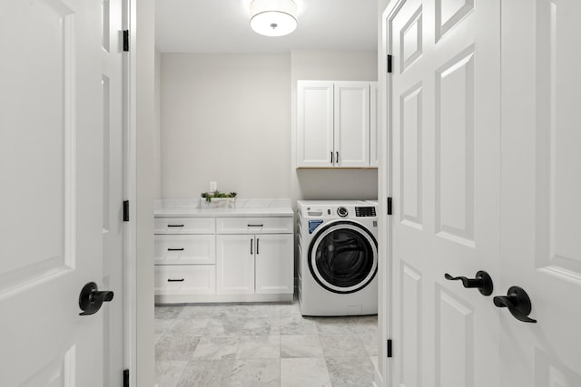 clothes washing area featuring cabinet space and washer / clothes dryer