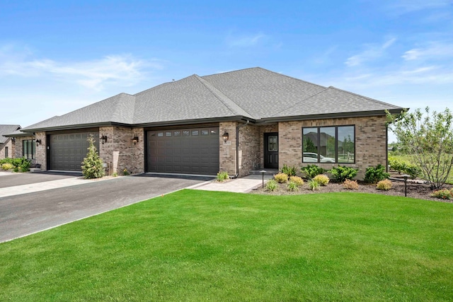 prairie-style house featuring a garage and a front lawn