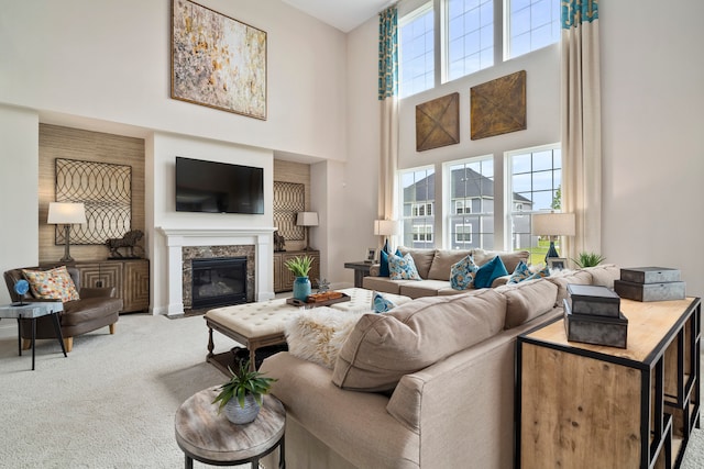 living room with a high ceiling, a fireplace, and carpet floors