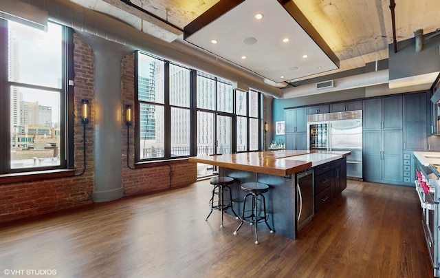 kitchen featuring a center island, a kitchen breakfast bar, high quality appliances, and dark hardwood / wood-style flooring