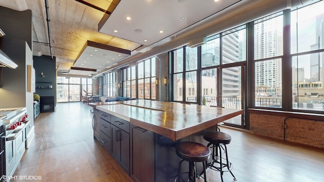 kitchen featuring a breakfast bar area, double oven range, a center island, and light wood-type flooring