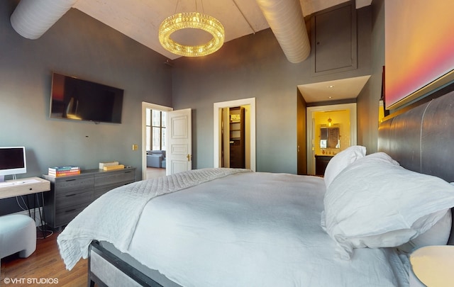 bedroom featuring a towering ceiling, a closet, and hardwood / wood-style flooring