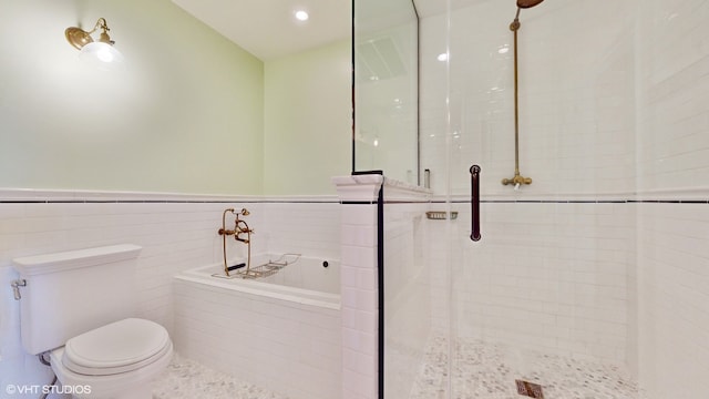 bathroom with a shower with door, toilet, and tile walls