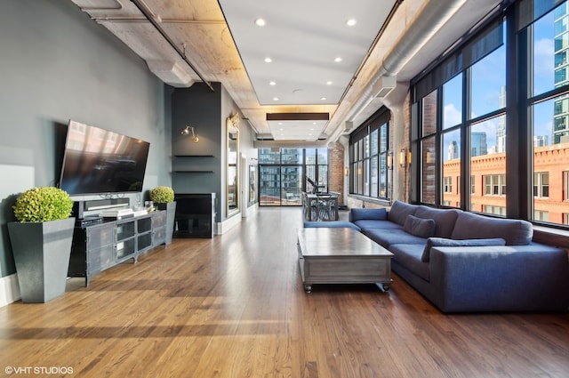 living room featuring a towering ceiling and hardwood / wood-style floors