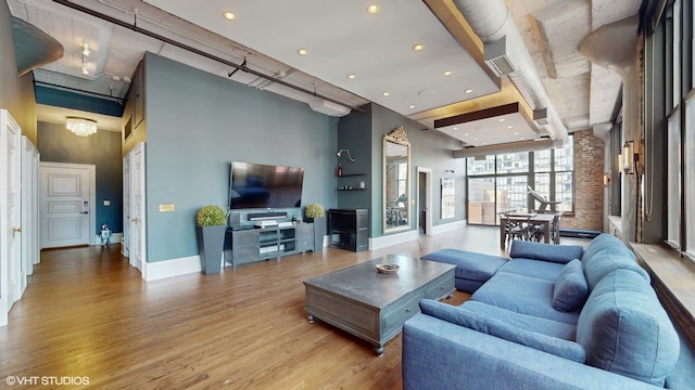 living room featuring a towering ceiling and light hardwood / wood-style flooring